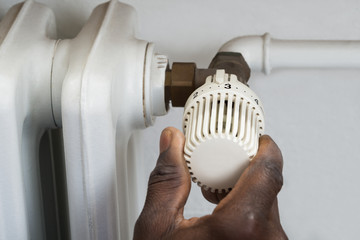 Person Hands Adjusting Thermostat Radiator