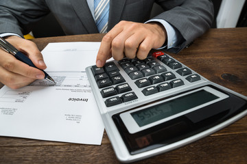 Businessperson Calculating Financial Sheet