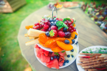 Beautifully decorated catering banquet table with different food snacks and appetizers with sandwich, caviar, fresh fruits on corporate birthday party event or wedding celebration 