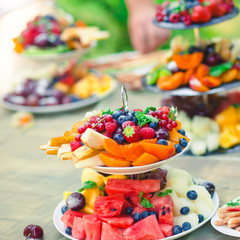 Beautifully decorated catering banquet table with different food snacks and appetizers with sandwich, caviar, fresh fruits on corporate birthday party event or wedding celebration 