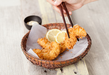Fried Chicken with sauce in a basket on a wooden table, Selective focus