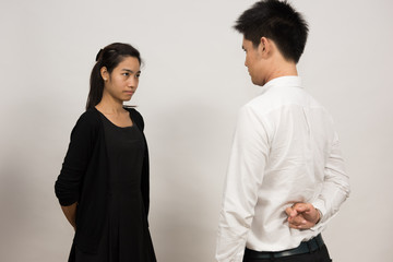 false deal, man and woman doing the handshake, the man crossed his fingers behind his back, isolated on white background.