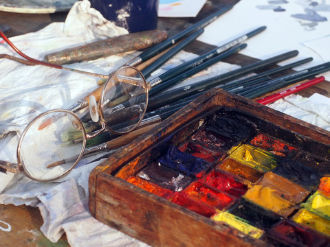 The workstation of a street painter in Venice - paints, brushes and glasses