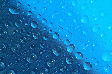 Water drops on the blue surface. Selective focus.