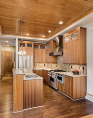 Beautiful kitchen in luxury home with hardwood floors and wood ceiling