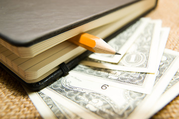 notebook, pencil and money on the old tissue