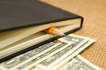 notebook, pencil and money on the old tissue