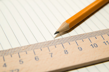 Notepads, pencil and wooden ruler on the old tissue