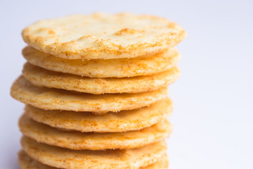 A stack of cheesy rice crackers on a white background.
