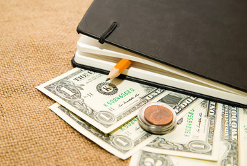 notebook, pencil and money on the old tissue