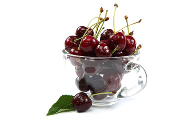 Fresh sweet cherries in a glass on a white background.