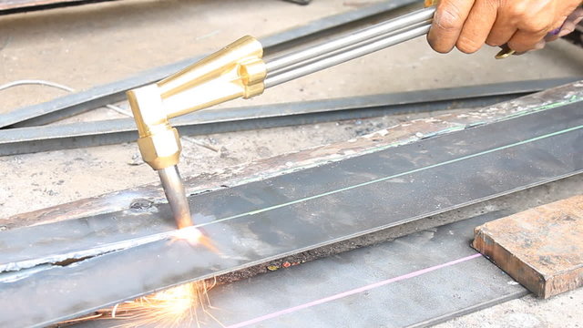 Metal Cutting With Acetylene Gas Oblique View with cutting torch. Spark splash around the ground.