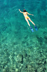 Young woman snorkeling in tropical sea