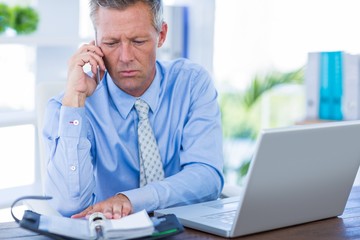 Fototapeta premium Serious businessman having phone call 