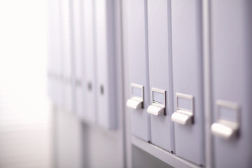 File folders, standing on  shelves in the background