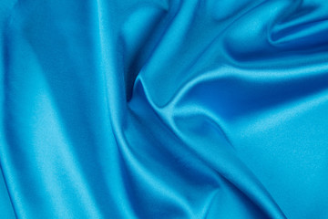 Soft folds of light blue silk texture.