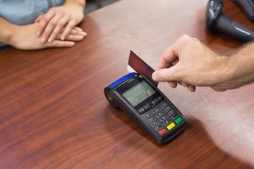 Woman at cash register paying with credit card