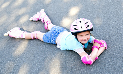 Cute smiling little girl in pink roller skates