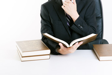 重厚な本を読むビジネスマン