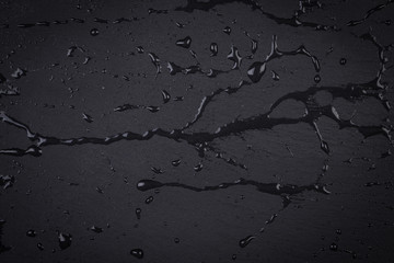 Fototapeta premium Water on dark stone surface