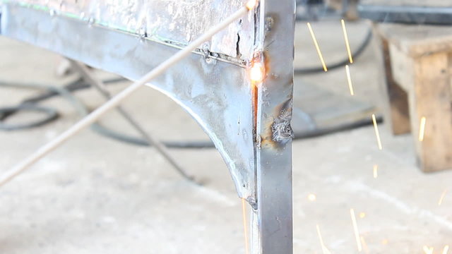 Stick Arc Welding at Vertical Position. Technician is welding car part in factory.