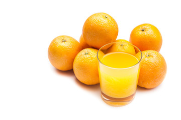 Fizzy orange juice from effervescent tablet with oranges at backdrop