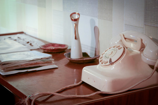 Retro desk. An retro scene of an old 1950's telephone in a contemporary setting with phone book on a side table.