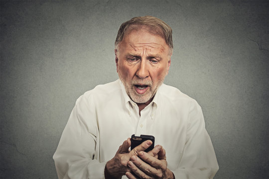 elderly man, shocked surprised by what he sees on his cell phone