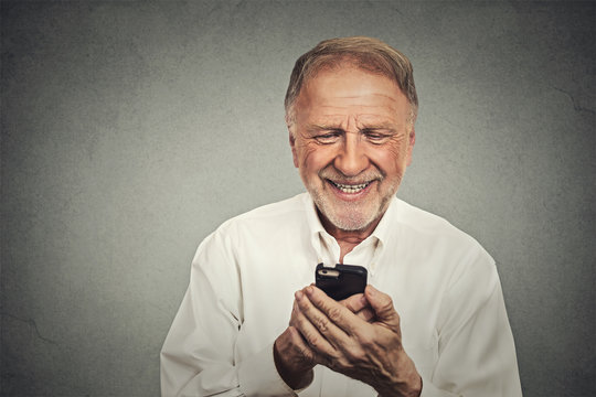 elderly man looking at his smart phone while text messaging