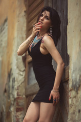 Obraz premium beautiful girl in a black dress stands near architectural struct