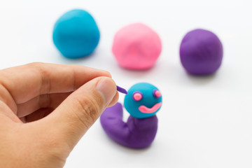 hand and plasticine on white background