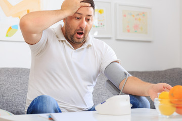 Man measuring his blood pressure surprised with his results