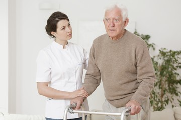 Senior man using walking frame