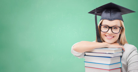 student in trencher cap with books over green