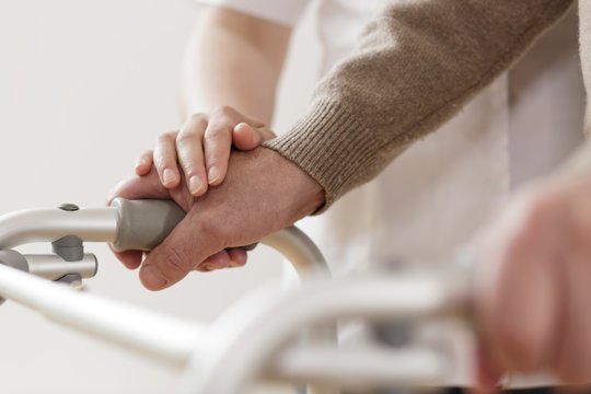 Physiotherapist supporting disabled man