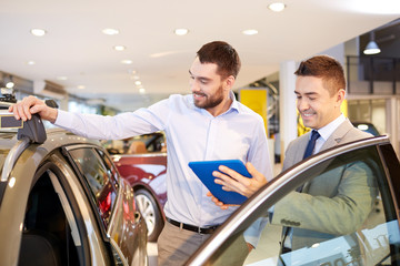 happy man with car dealer in auto show or salon