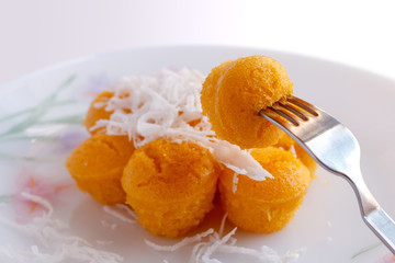 Toddy palm cake topped with coconut on the utensils.