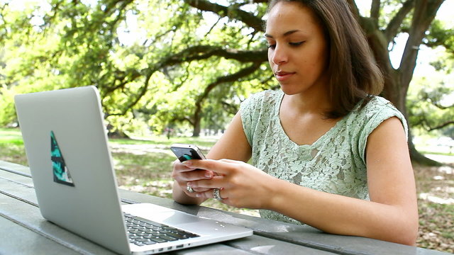 Black woman using technology in a park