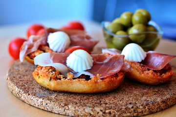 Bruschetta with prosciutto and mozzarella on a wooden table