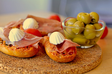 Bruschetta with prosciutto and mozzarella on a wooden table