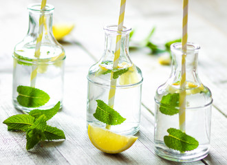Lemonade with fresh lemon on wooden background