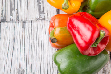 Fresh colorful bell peppers on a rustic wooden background