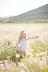 Fototapeta na wymiar Cute child girl at camomile field