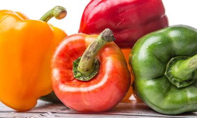 Fresh colorful bell peppers on a rustic wooden background