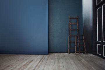 Two Wooden ladder, near dark blue wall, perspective    