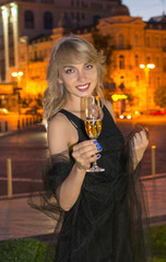 Girl with a glass of champagne at night