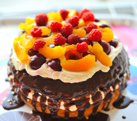 Cake with fruit, berries and butter cream, raspberry, peach, cherry, chocolate