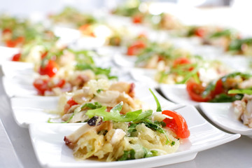 Swedish table appetizers: tomatoes, cheese, arugula, octopus, on