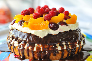 Cake with fruit, berries and butter cream, raspberry, peach, cherry, chocolate