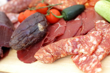 smoked meat products, vegetables on the table